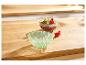Zwei Glasschalen, eine mit Schokoladendessert und Beeren, auf einem Holztisch.