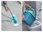 Frau wischt den Boden mit einem Mopp und leert einen Eimer in die Toilette.