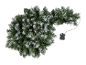 Beschneite Weihnachtsgirlande mit Steuerbox auf schwarzem Hintergrund.