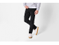 Mann in schwarzer Cordhose, grauem Hoodie und weißen Sneakern.