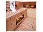 Holzsauna-Interieur mit zwei Infrarotstrahlern und einem weißen Handtuch.