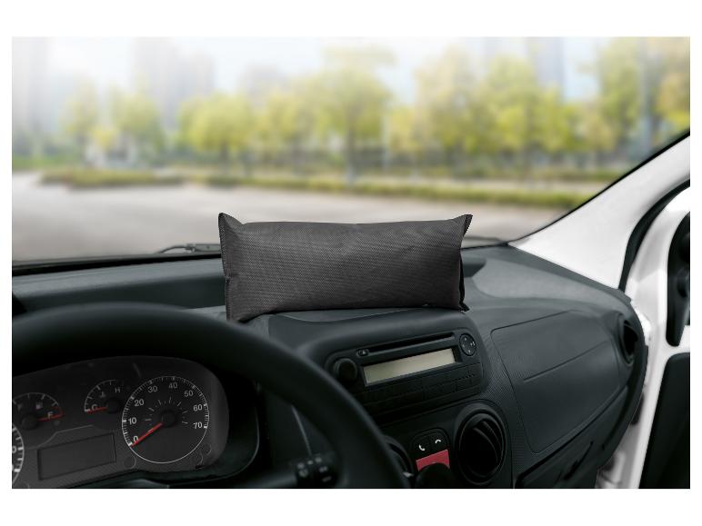 Schwarze rechteckige Tasche auf dem Armaturenbrett eines Autos mit verschwommener Außenlandschaft