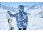 Snowboarder in blauer Skijacke mit Kapuze hält ein Snowboard in den Bergen.