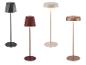 Vier moderne Stehlampen in Schwarz, Rot, Beige und Kupfer, mit geometrischen und runden Schirmen.