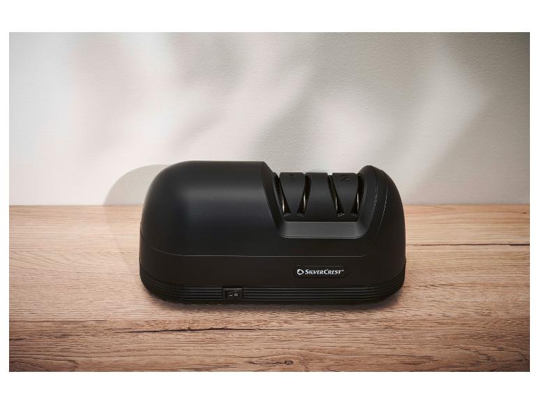 Schwarzer SilverCrest Elektromesser-Schärfer auf einer Holztheke.