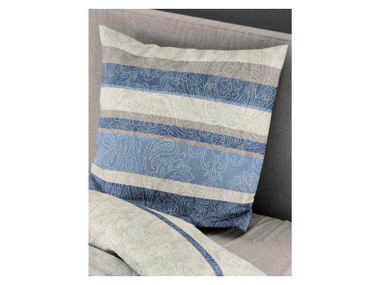 Ein gestreiftes Kissen mit Paisley-Muster in Blau und Grau auf einem Bett.