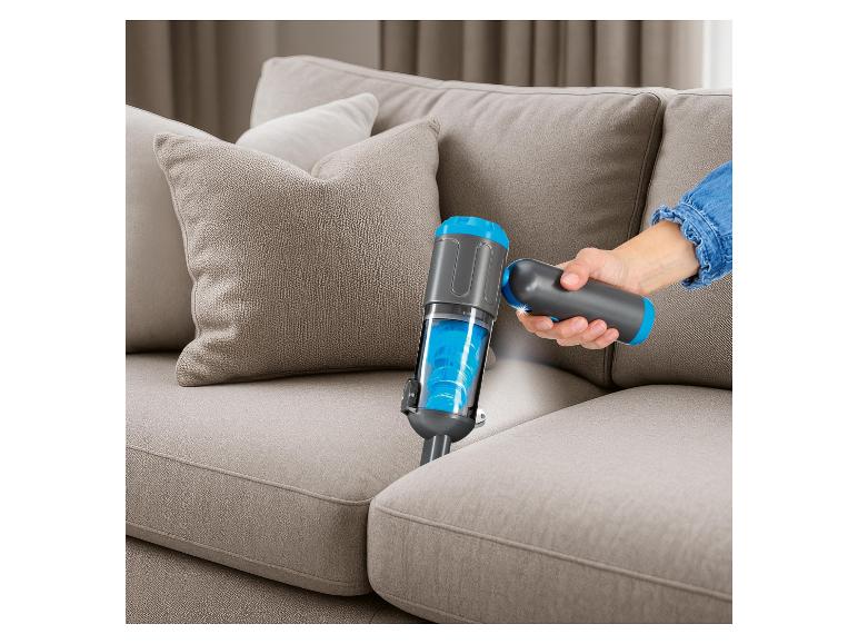Handstaubsauger mit Licht, der ein beiges Sofa reinigt.