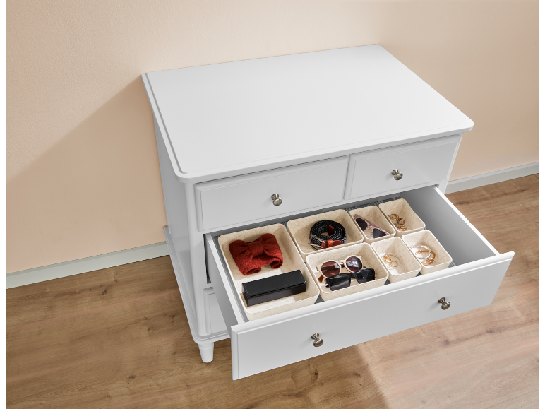 Weiße Kommode mit geöffneter Schublade, die Organizer für Accessoires enthält.