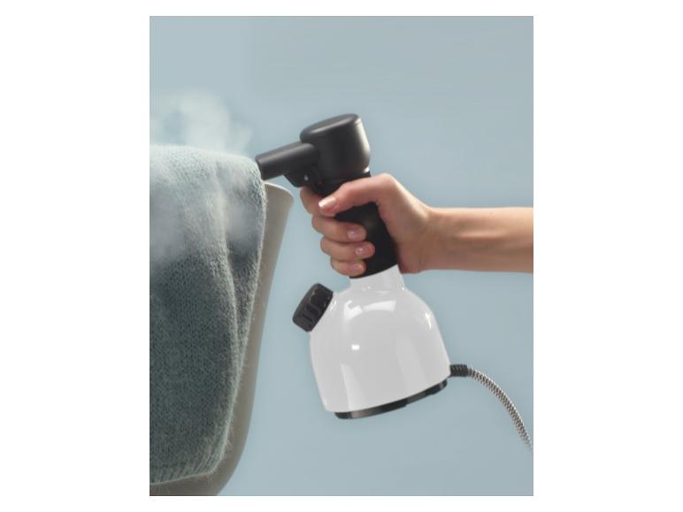 Eine Hand hält einen weißen und schwarzen Dampfglätter und benutzt ihn an einem blauen Kleidungsstück.