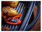 Gegrillter Kartoffeln und Paprika auf einem Gusseisenrost.