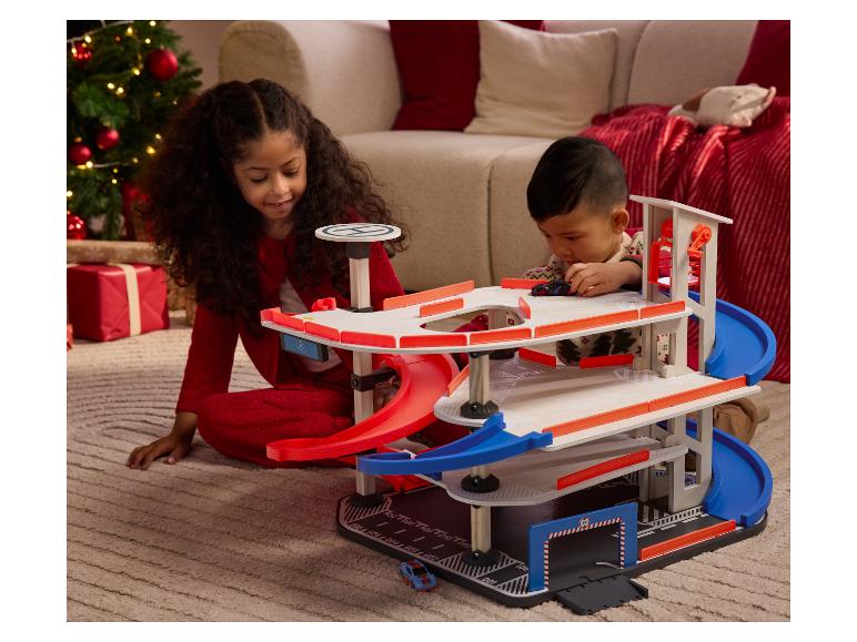 Zwei Kinder spielen mit einer mehrstöckigen Holzspielzeuggarage.
