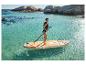 Frau in Badeanzug und Schwimmweste beim Stand-Up-Paddling in türkisfarbenem Wasser mit Felsen im Hintergrund.