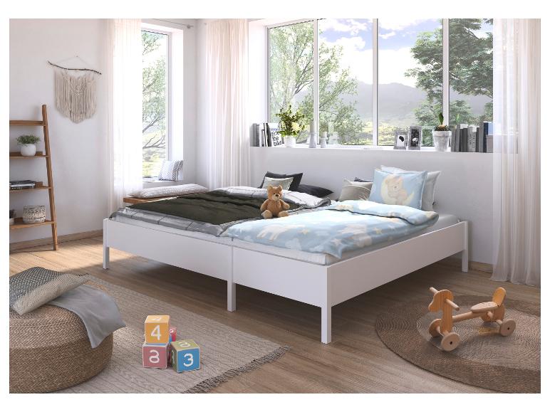 Helles Kinderzimmer mit zwei weißen Betten, Spielzeug und Naturblick.