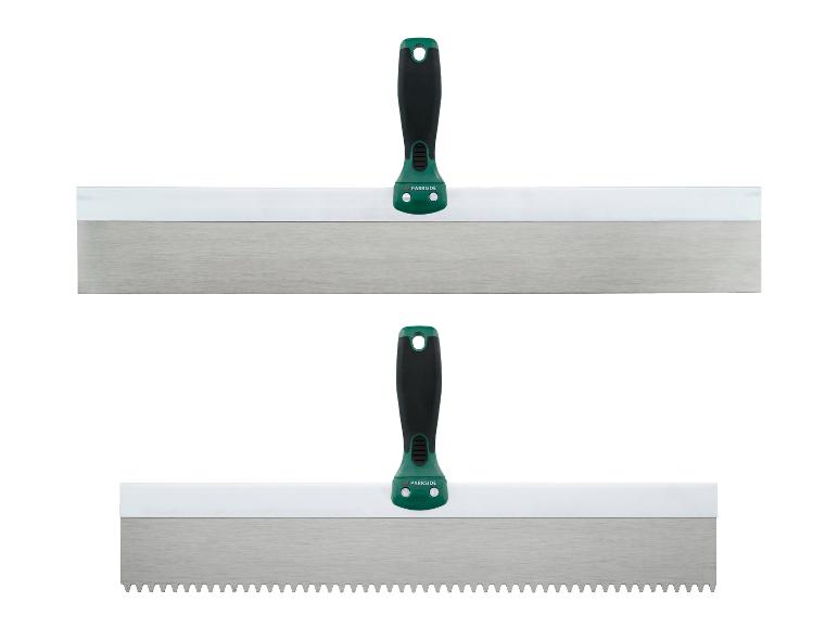 Zwei Spachteln, eine glatt und eine gezahnt, mit grünen Griffen.