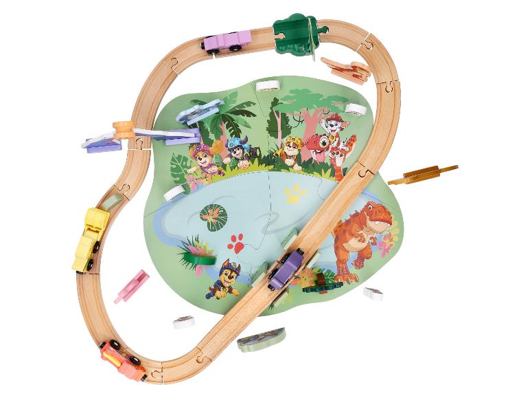 Holzeisenbahn mit Zeichentrickfiguren und einem Dinosaurier auf einer Spielmatte.