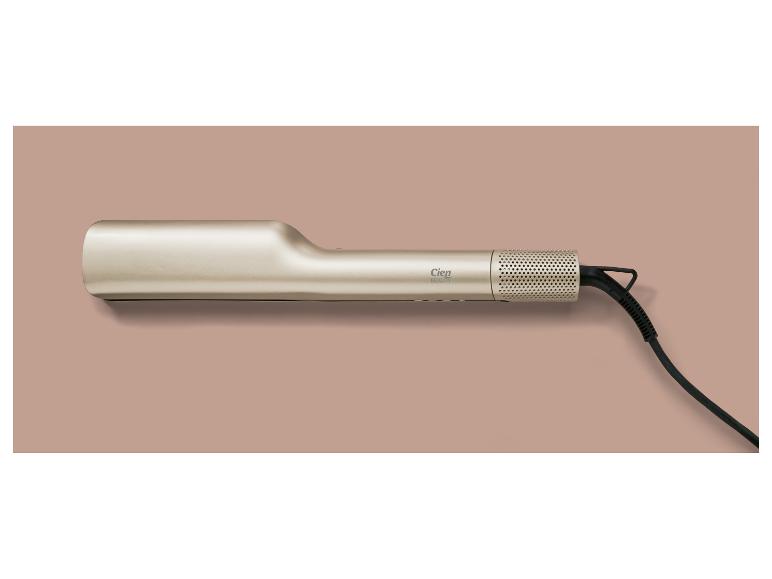 Goldener Cien Beauty Haarglätter mit schwarzem Kabel auf rosa Hintergrund
