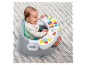 Baby in einem Aktivitätssitz mit Musik und Spielzeug.