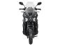 Schwarzes Motorrad mit Windschutzscheibe und Stollenreifen, Vorderansicht.