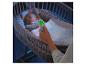 Digitales Thermometer zeigt 20.5°C, mit schlafendem Baby in einer Wiege im Hintergrund.