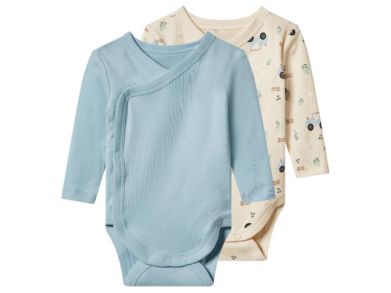 Zwei langärmelige Babybodys: ein hellblauer Wickelbody und ein beiger mit Bauernhofmuster.