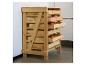 Holzschrank mit Schubladen voller Äpfel, an einer weißen Wand.