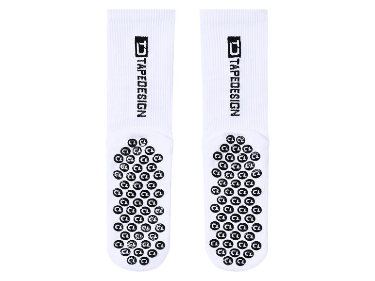 Zwei Paar weiße Sportsocken mit schwarzen Anti-Rutsch-Noppen und dem Text „TAPEDESIGN“.