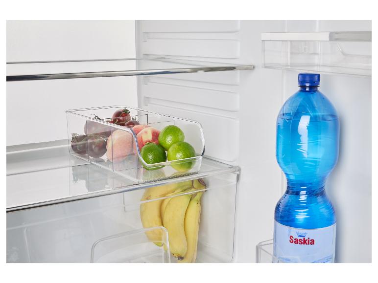 Ein Kühlschrank mit Obst, Gemüse und einer Flasche Saskia Wasser.