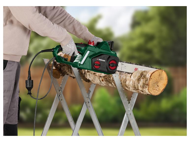 Ein Mann verwendet eine Parkside Elektro-Kettensäge, um Holz auf einem Bock zu sägen.
