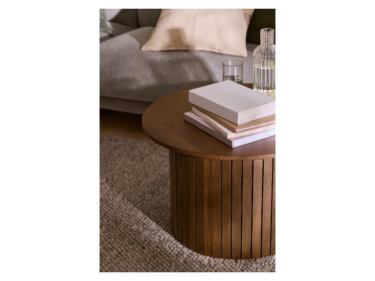 Runder Couchtisch aus Holz mit Büchern und Wasserflasche im Wohnzimmer.