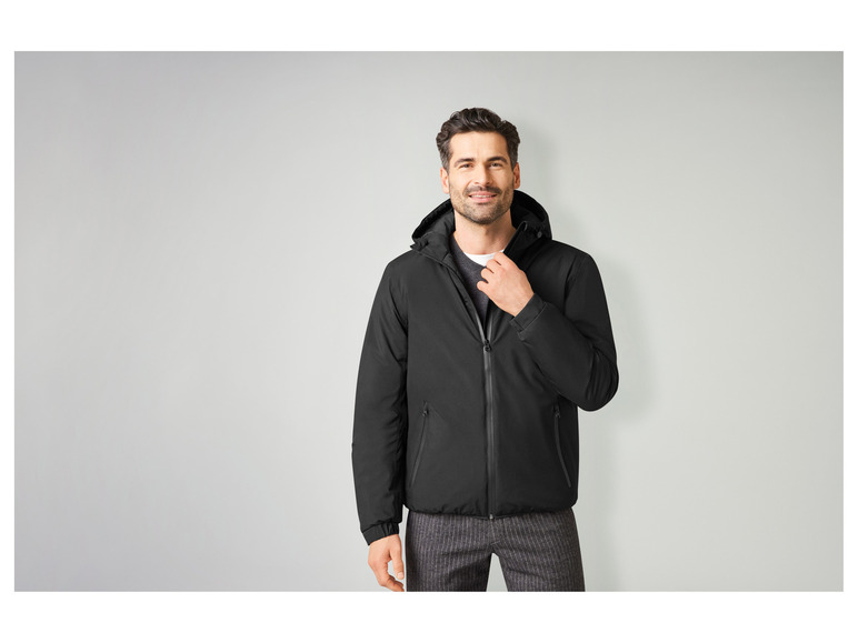 Mann trägt eine schwarze Jacke mit Kapuze.