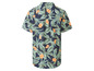 Ein blaues Hemd mit kurzen Ärmeln und tropischem Muster.
