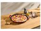 Pizza mit Salami, roten Zwiebeln und Paprika in einer Gusseisenpfanne auf einem Holztisch.