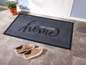 Eine graue Fußmatte mit dem Text 'Welcome home'.