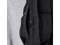 Detail einer schwarzen Steppjacke mit Seitentasche und Druckknopf.