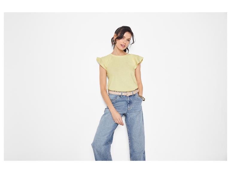 Frau in gelbem Kurzarmshirt und weiter Jeans.