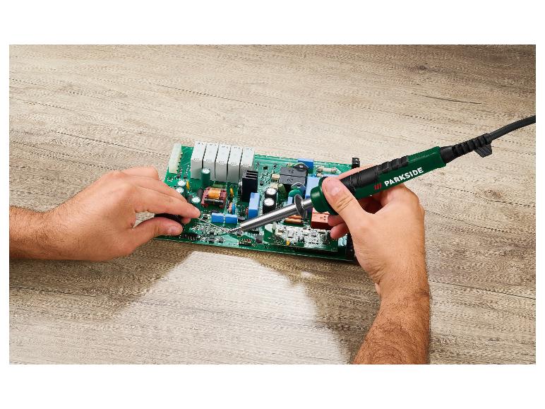 Mann lötet eine Platine mit einem Parkside Lötkolben.