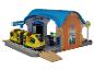 Spielset Bahnhof mit gelbem Zug und Schaffnerfigur.