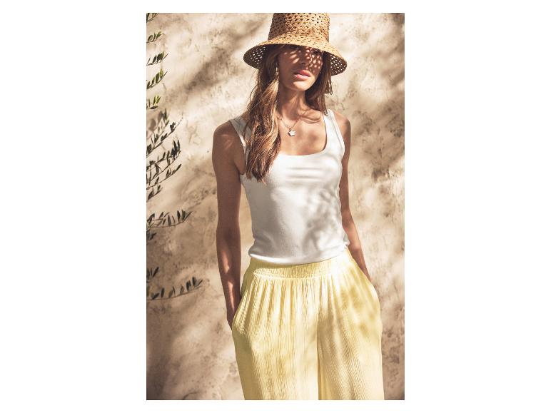 Frau im ESMARA® Tanktop und gelber Hose mit Strohhut.