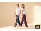 Mann und Frau in weißen T-Shirts und karierten Pyjamahosen, lächelnd.
