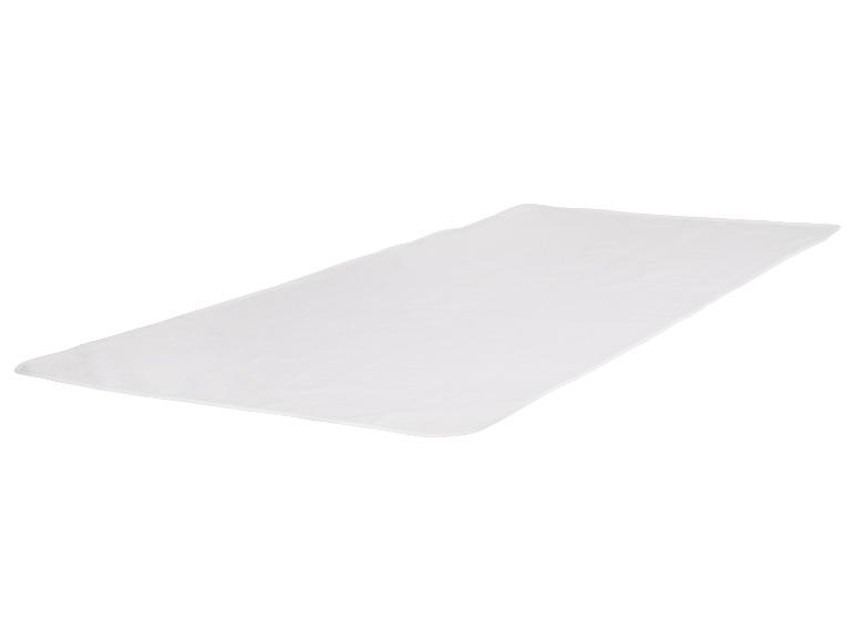 Eine weiße, rechteckige Decke auf einer weißen Oberfläche ausgebreitet.