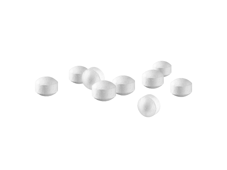 Weiße runde Tabletten auf schwarzem Hintergrund.