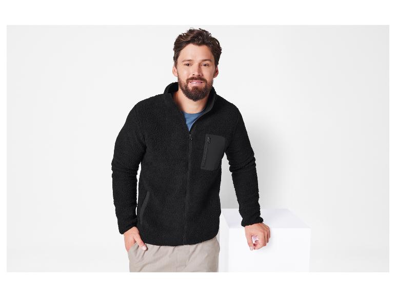 Mann trägt eine schwarze Fleecejacke mit Reißverschluss.