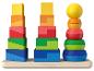 Drei bunte Stapeltürme aus Spielzeug auf einem Holzregal.