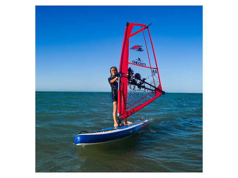 Eine junge Frau windsurft auf einem SUP-Board mit einem Checker 3.5 Segel.
