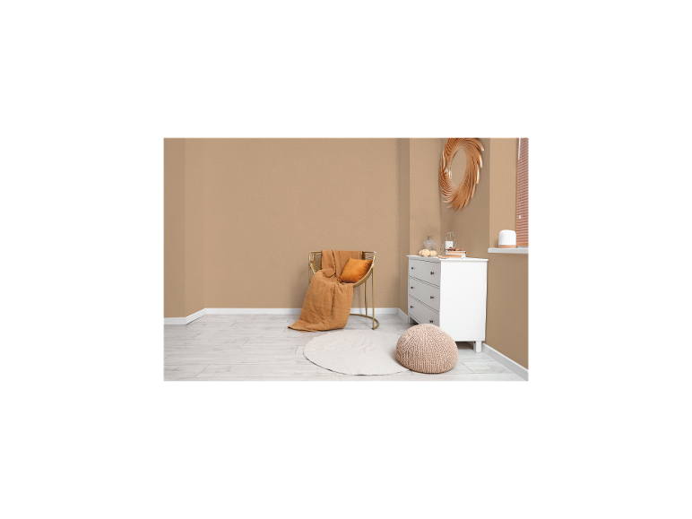 Gemütliches Zimmer mit goldenem Stuhl, orangefarbener Decke, weißer Kommode und rundem Teppich.