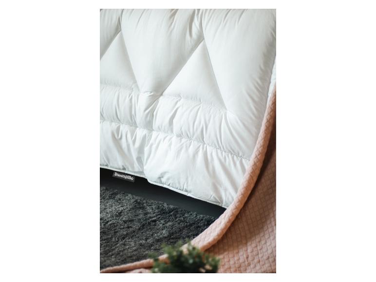 Weiße Dunlopiilo-Bettdecke mit einer rosa Decke und einem grauen Teppich.