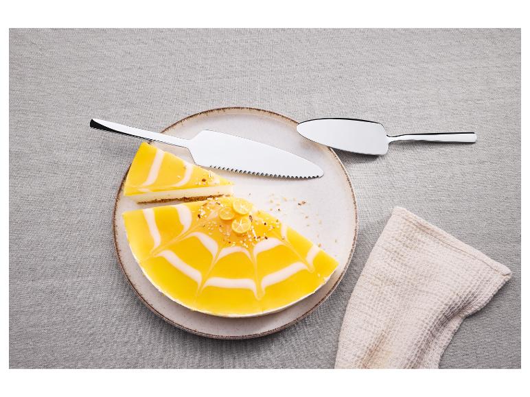 Kuchenbesteck mit Messer und Heber, daneben Zitronenkäsekuchen auf einem Teller.