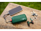 Grüne Powerbank lädt ein Smartphone, mit Schlüsseln und Mini-Bohrmaschinen-Schlüsselanhänger.