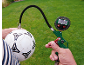 Digitales Reifendruckmessgerät pumpt einen Fußball auf grünem Rasen auf.