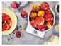 Küchenwaage mit Äpfeln, Tortenboden mit Marmelade und Backzutaten.